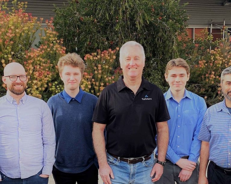 Staff in front of flowers web