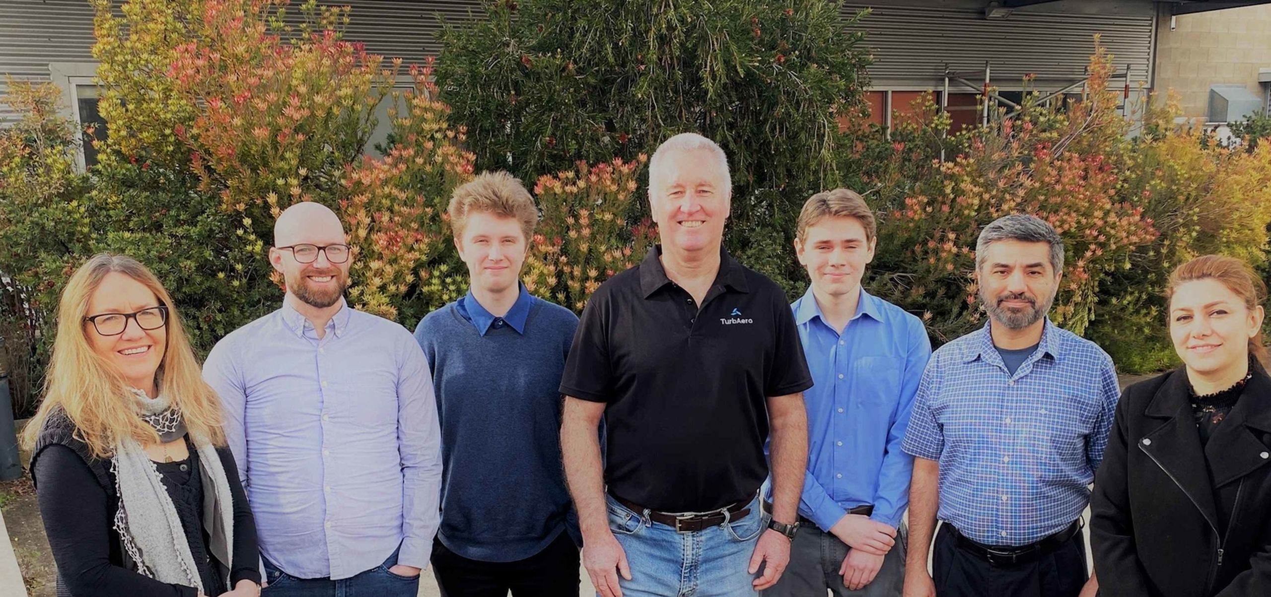 Staff in front of flowers web
